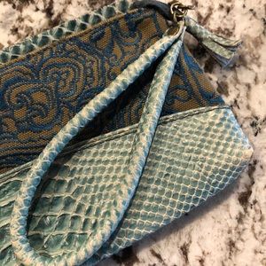 Wristlet that is embroidered cloth faux leather